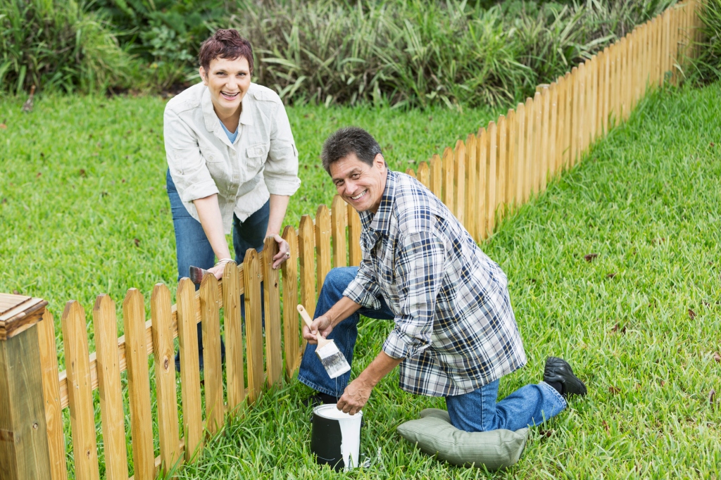 A man and woman making a clear boundary with a wooden fence between them